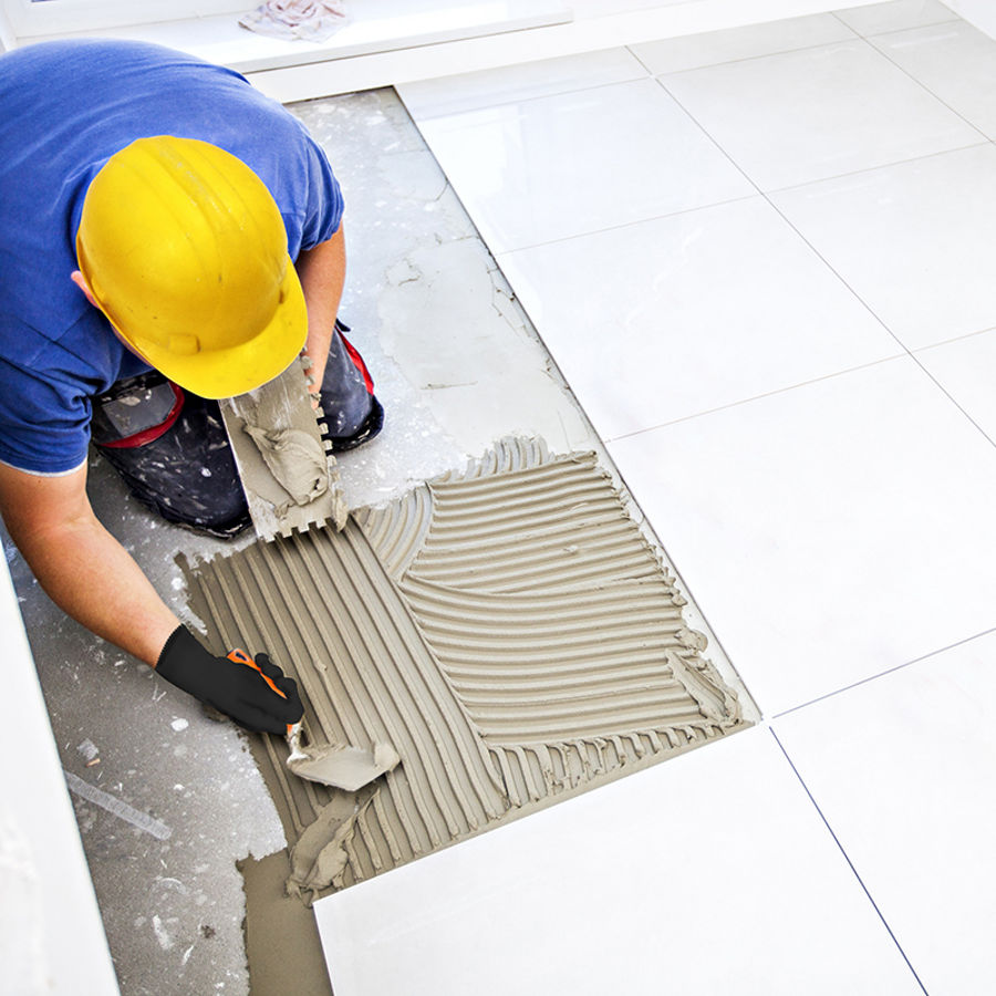 Construction worker applying tile adhesive